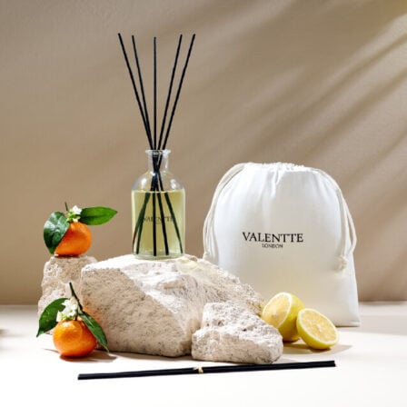 Our White Neroli large diffuser on a rock surrounded by neroli and lemon
